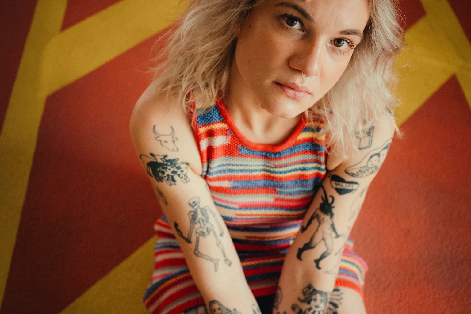 AVEC seated on a colorful floor